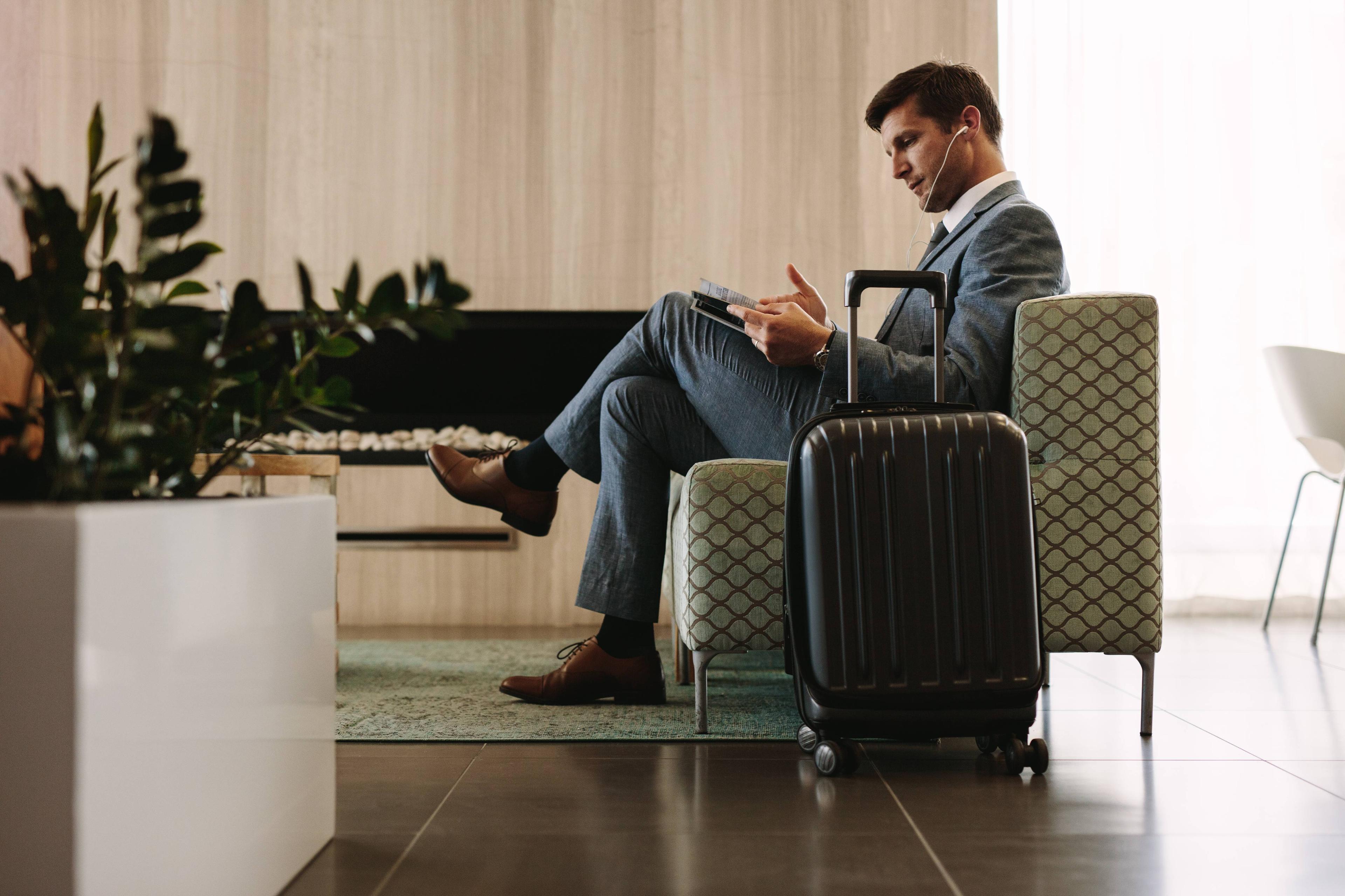 man sitting with suitcase next to him