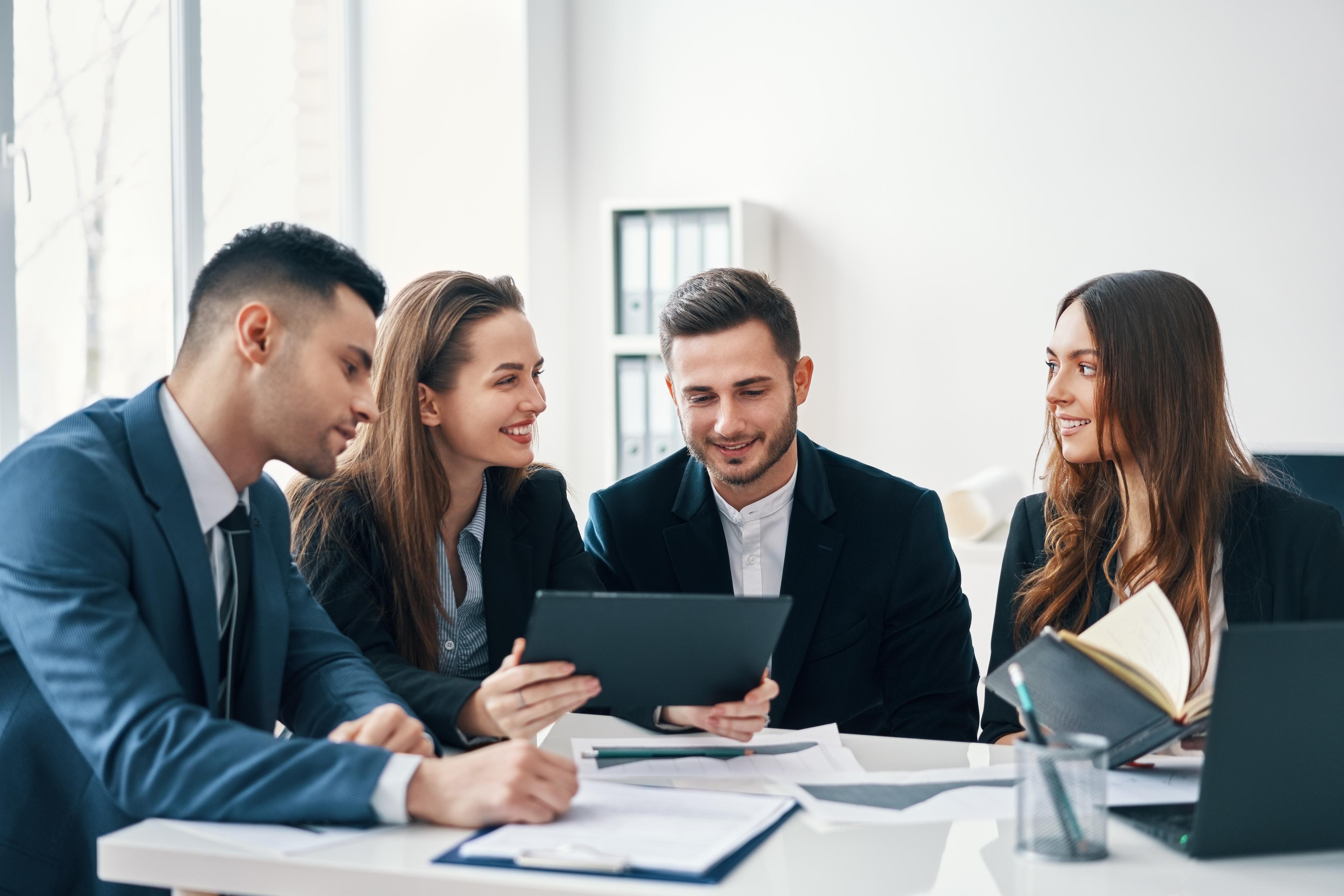 people working together and looking at a tablet